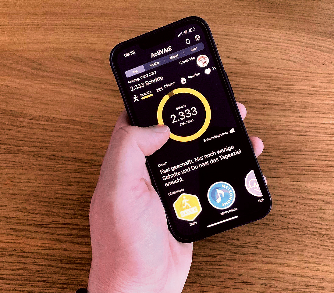 Eine Hand hält ein Handy. Das Display zeigt an, dass mit 2.333 Schritten das festgelegte Ziel fast erreicht ist.